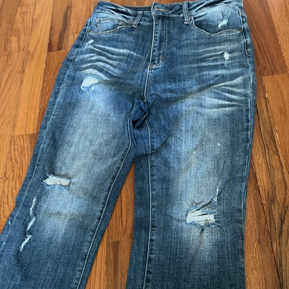 Risen jeans. Distressed with holes in front and rips on back pockets.